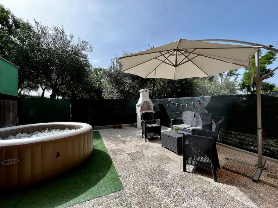 Cassero的住宿－[Idromassaggio] Relax, wi-fi, bbq & parcheggio，庭院配有遮阳伞和桌椅。