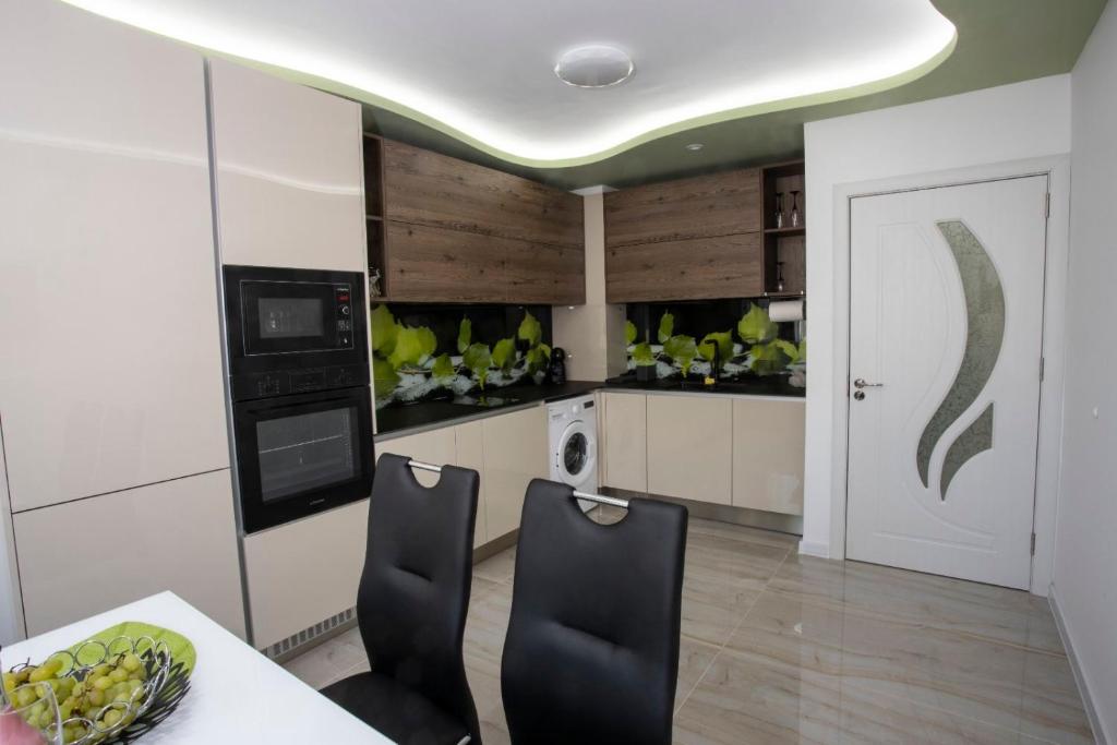 een keuken met een tafel en 2 stoelen in een kamer bij Апартамент за гости Ивви-2 in Boergas