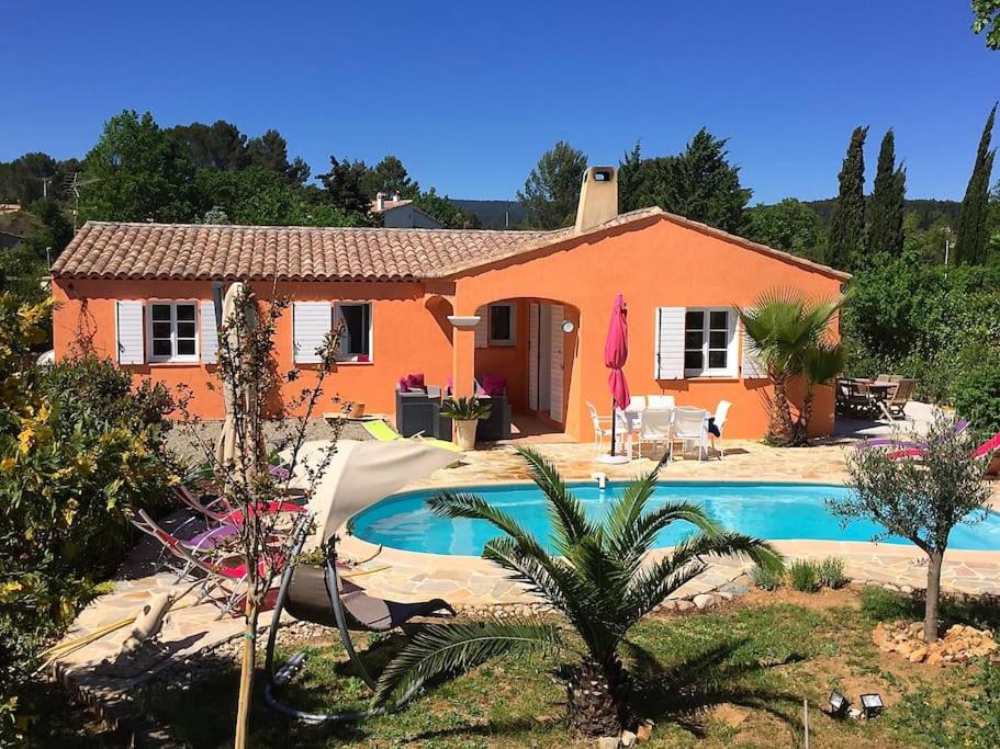 een huis met een zwembad ervoor bij villa des chênes in Flayosc