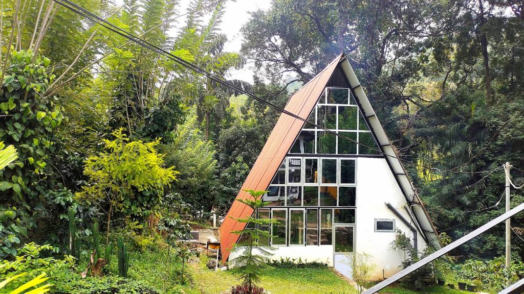 a small house with a triangular roof in a garden at Riverston Nature Villa in Rattota
