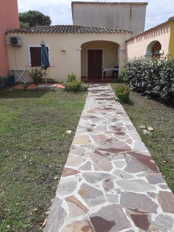 een stenen loopbrug voor een huis bij casa mirice in residence con piscina ,wifi,climatizzatore vicino al mare in Aglientu