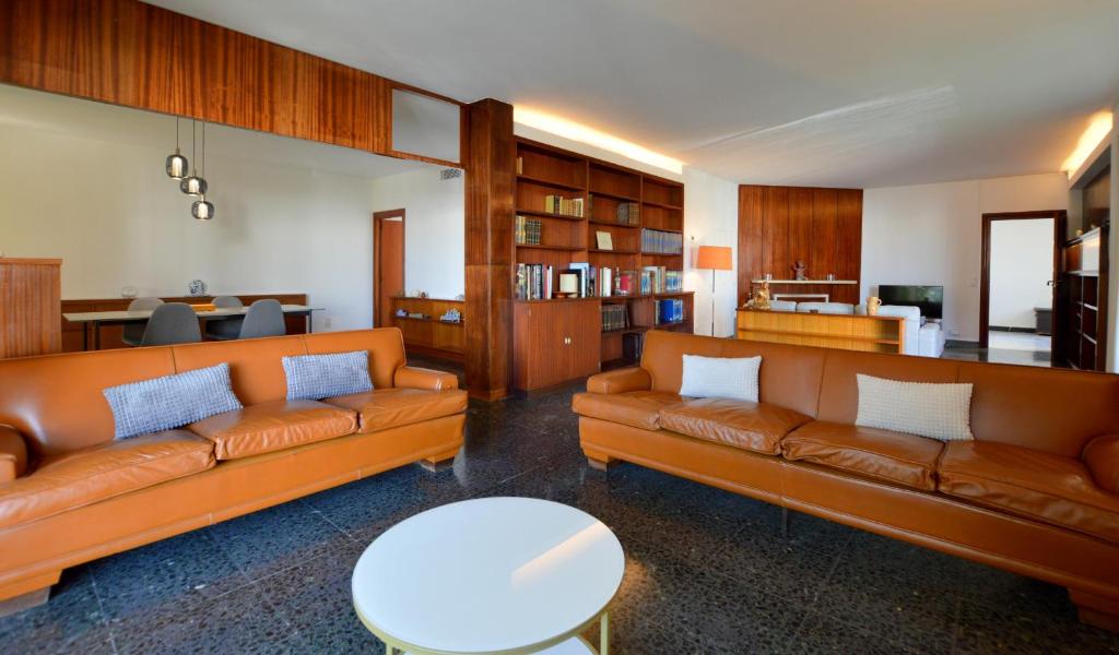 a living room with two leather couches and a kitchen at Villa Palma 2 in Palma de Mallorca