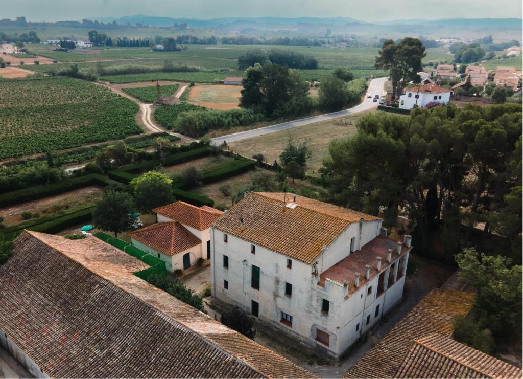 Vilobi Del Penedes的住宿－Casa Rural Cal Gotlla，房屋和道路的空中景观