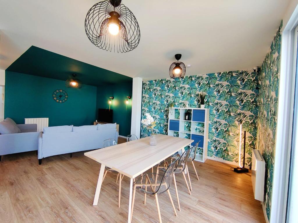 een woonkamer met een tafel en een bank bij Chambre Crozon avec salle de bains privative dans une résidence avec salon et cuisine partagés in Brest