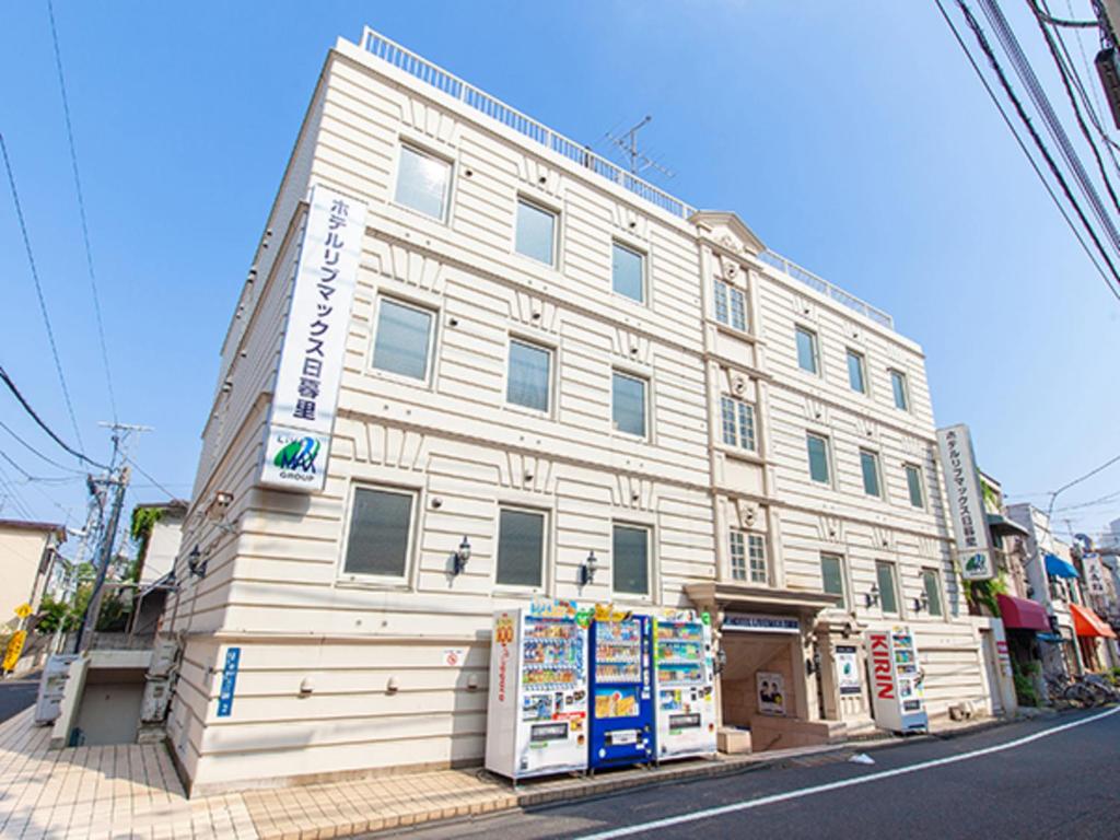 un gran edificio blanco en la esquina de una calle en HOTEL LiVEMAX BUDGET Nippori en Tokio