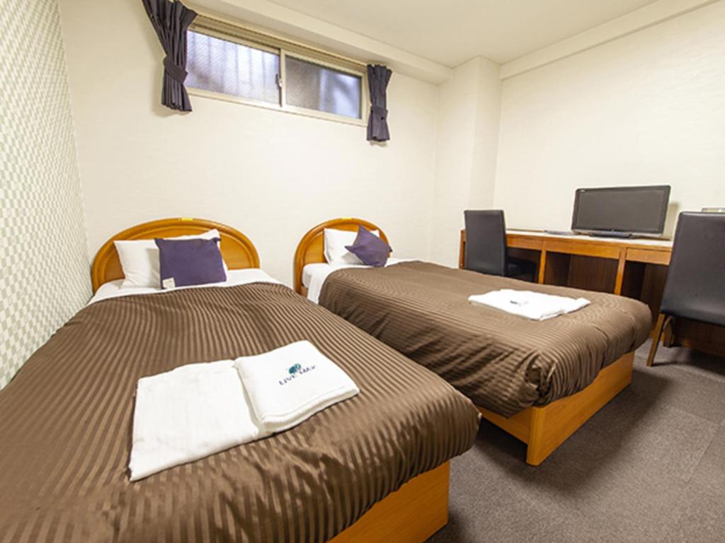 Postel nebo postele na pokoji v ubytování HOTEL LiVEMAX BUDGET Nippori