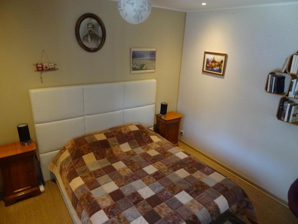 a bedroom with a bed and a clock on the wall at Les Chambres de la Forêt in Juvigny-sous-Andaine