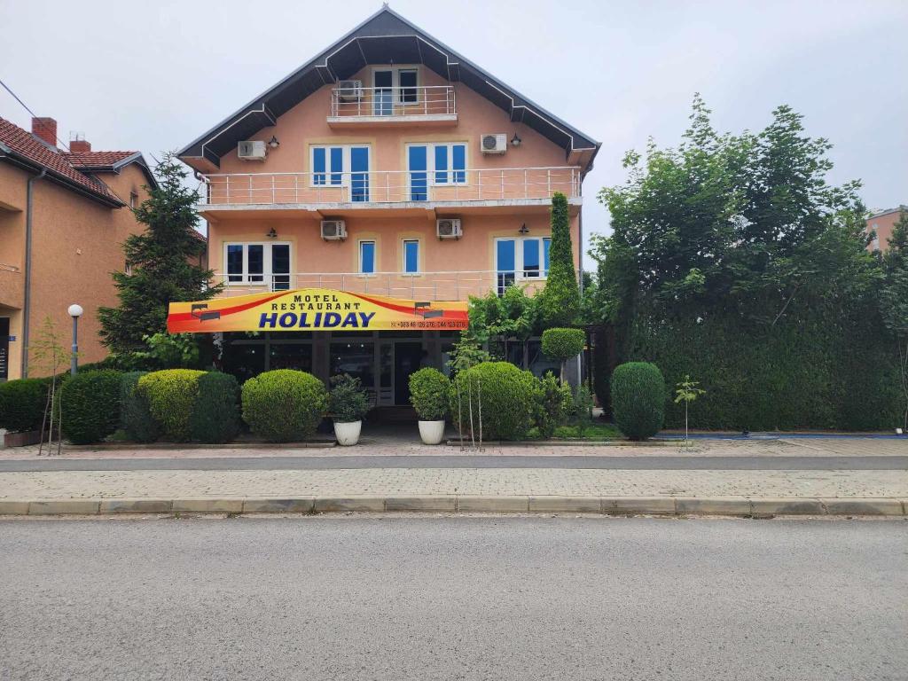 a building with a sign for a hotel at Holiday in Ferizaj