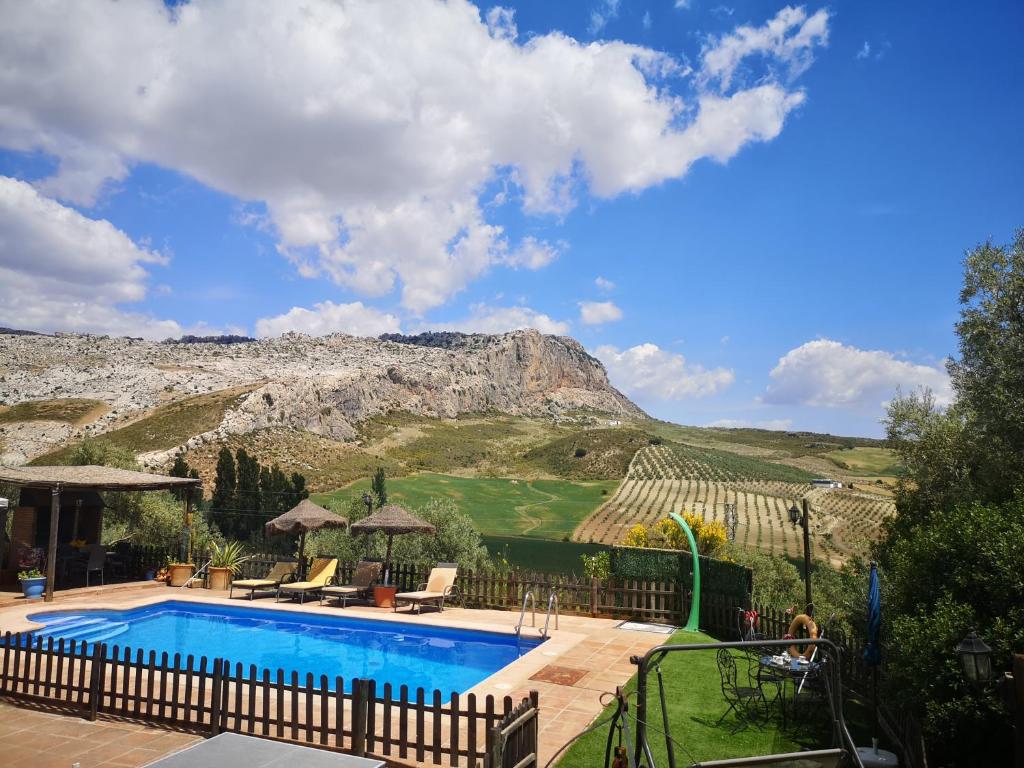 a swimming pool with a mountain in the background at CASA RURAL EL CHAPARRO in Antequera