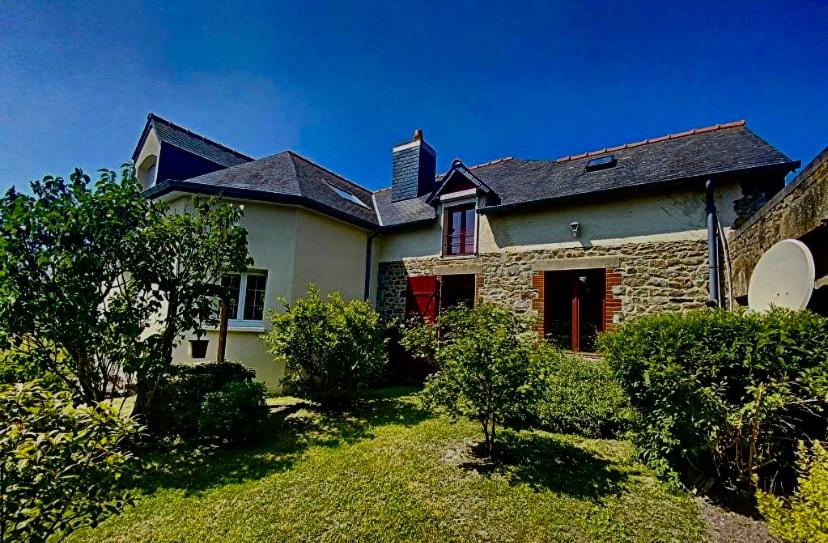 a stone house with a red door in a yard at Chez Maurice - Stylish French Country House in Cherrueix