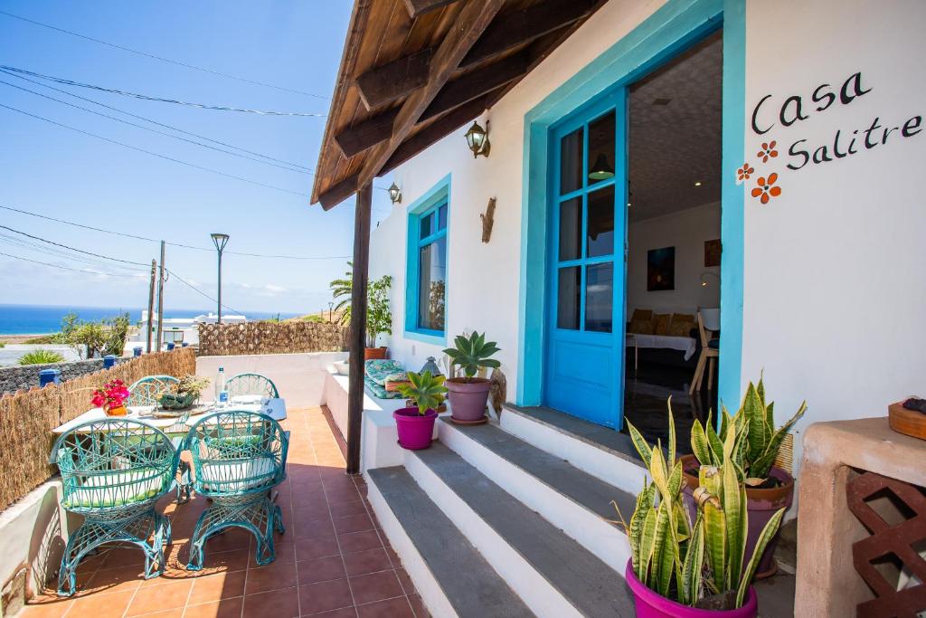 TabayescoにあるEco Casa Salitre,Montaña, Campo y Playaの青いドアと椅子、植物のあるパティオ