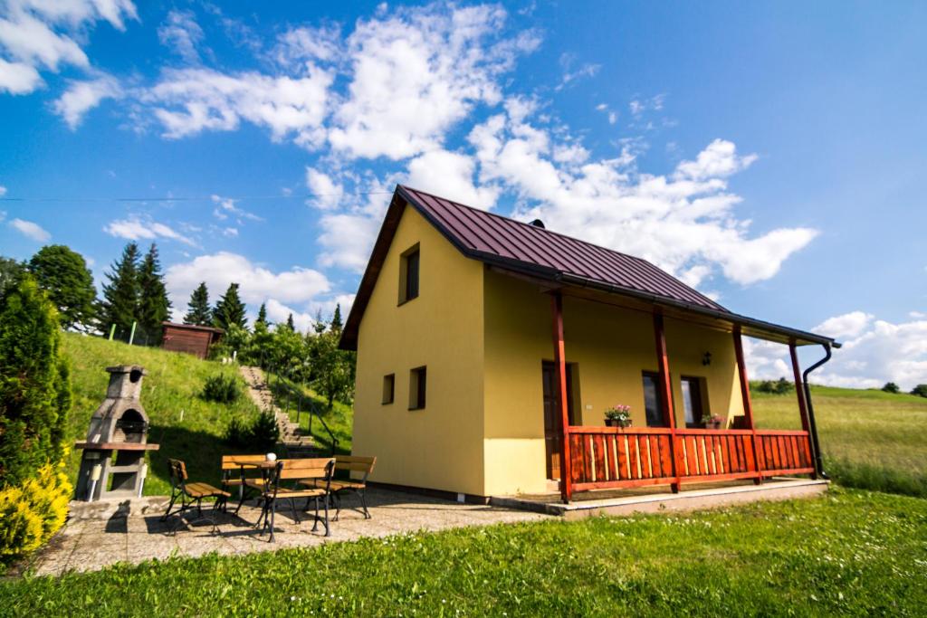 a small yellow cottage with a table and chairs at Chata Alex Liptov in Trstené