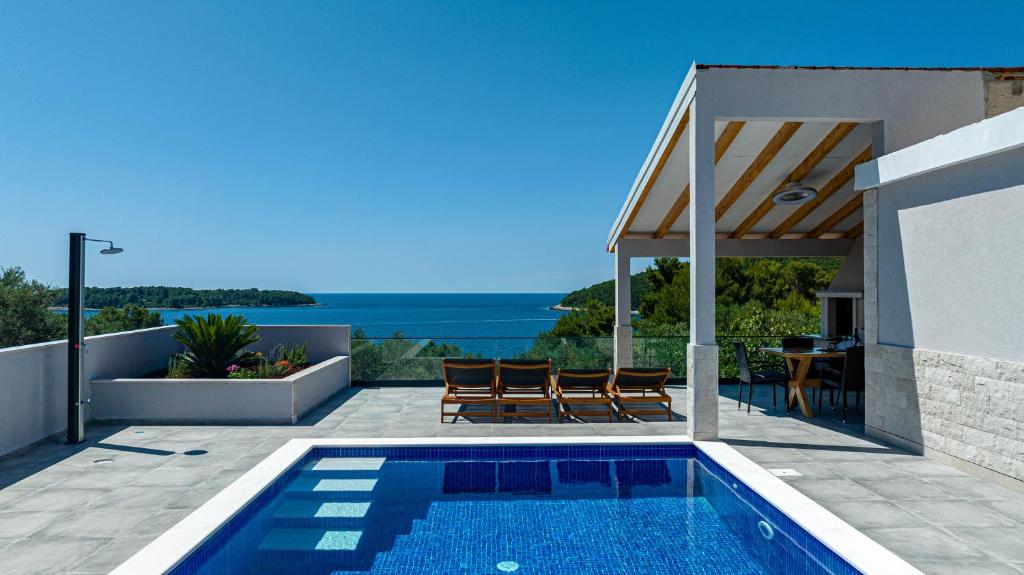 a villa with a swimming pool and a view of the ocean at Villa Blue Panorama in Vela Luka