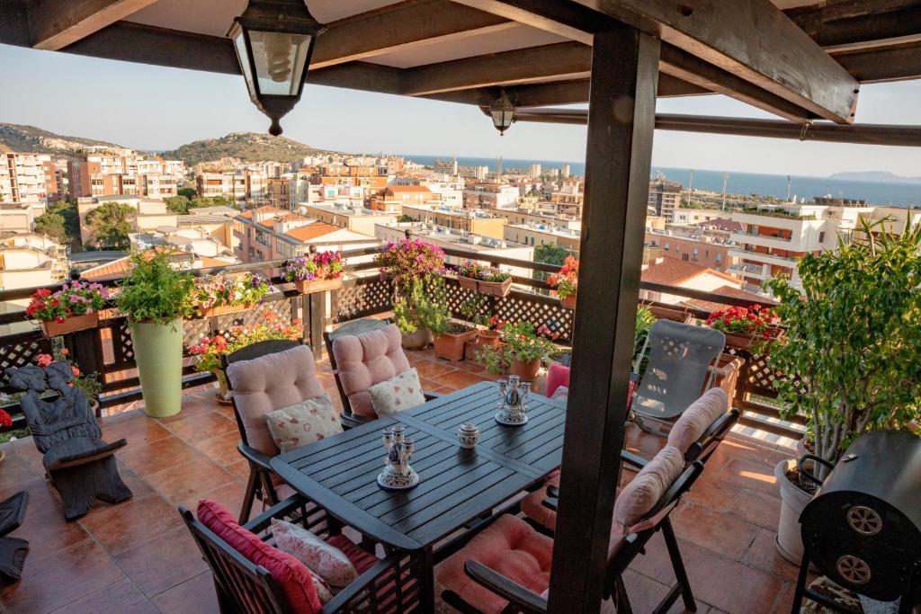 a patio with a table and chairs on a balcony at Prestigioso Attico Panoramico Cagliari in Cagliari