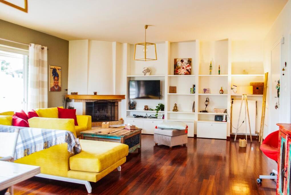 a living room with a yellow couch and a fireplace at Spacious and Modern Apt in the Suburbs of Athens in Athens