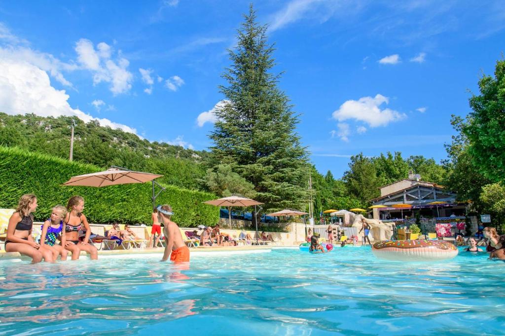 een groep mensen in het water bij een zwembad bij Le Clos de Barbey in Bauduen