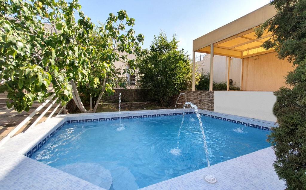 a swimming pool with a water fountain at Al Estraha Al Raqia Vila in Al Hada