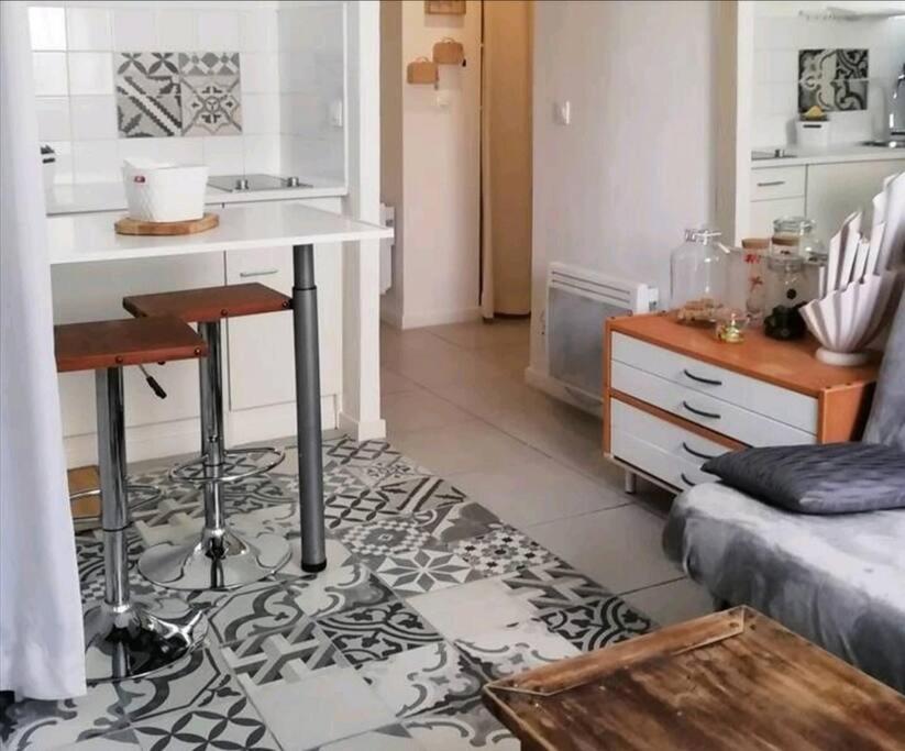 a living room with a table and a kitchen at L&#39;Ornella Dom Studio en copropriété in Marseille