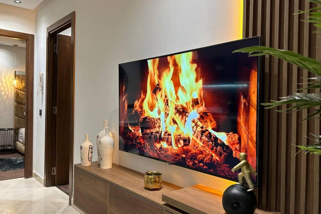 a living room with a tv with a fire in it at Sunny 2 Bedrooms - By AppartAli in Casablanca