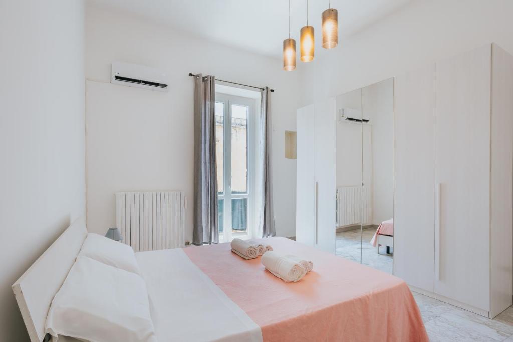 biała sypialnia z łóżkiem z 2 poduszkami w obiekcie B&B Nuovo Reale - CENTRO STORICO w mieście Lecce