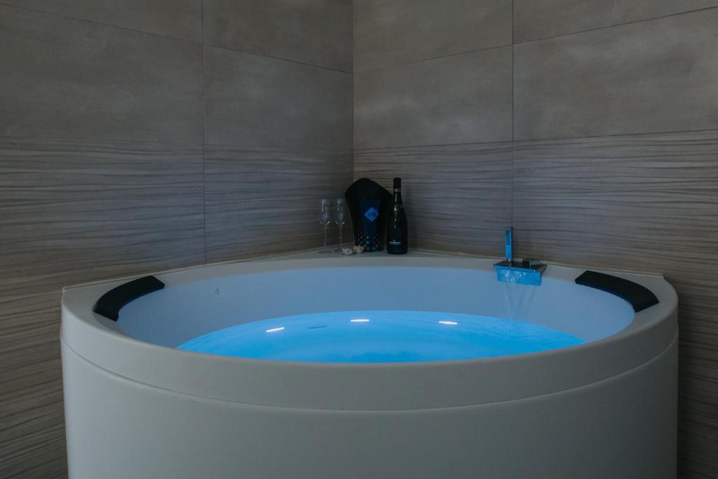 uma casa de banho com uma banheira com água azul em B&B Nuovo Reale - CENTRO STORICO em Lecce