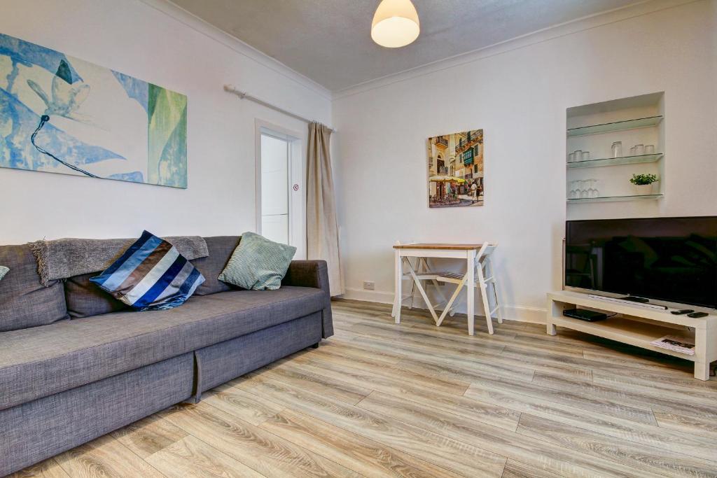 a living room with a couch and a flat screen tv at Apartment Caerlaverock Road in Prestwick