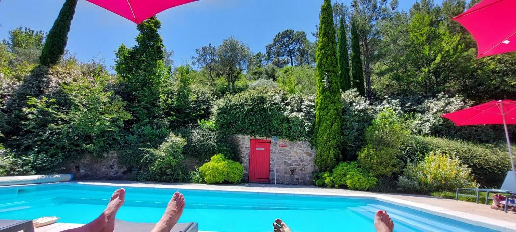 une personne assise dans une chaise à côté d'une piscine dans l'établissement Le Mas de Trépeloup, à Alès