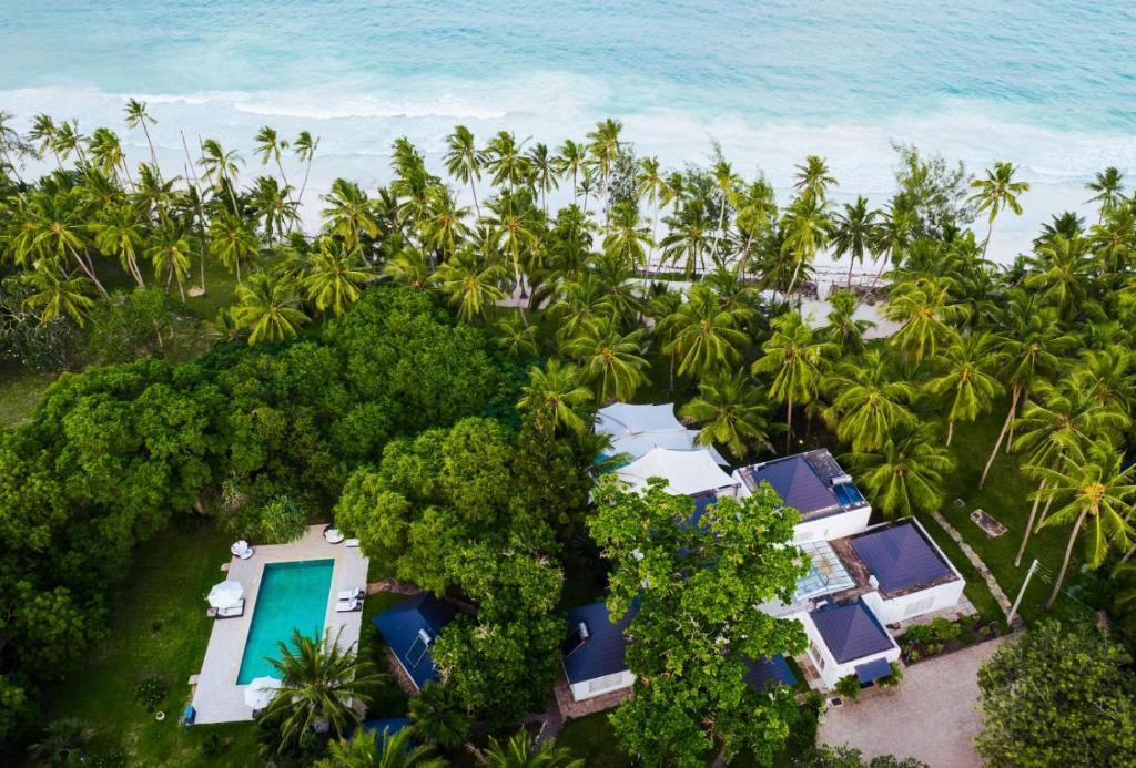 einen Luftblick auf ein Resort mit Palmen und dem Meer in der Unterkunft Searenity Beach Villa in Diani Beach