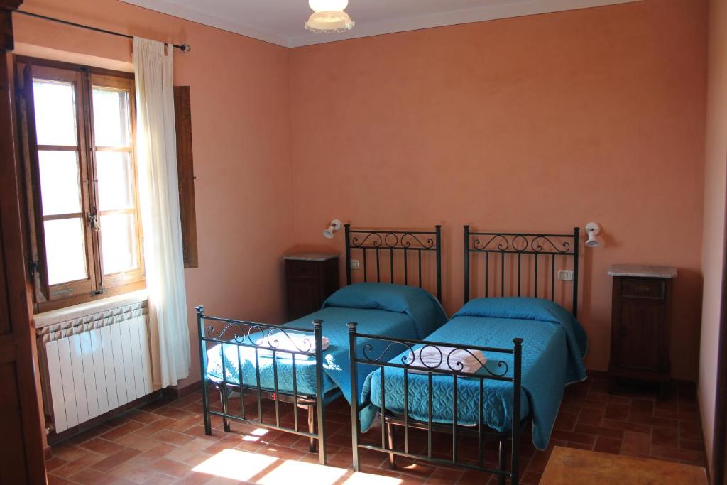アシャーノにあるAgriturismo Calianoのベッドルーム1室(ベッド2台、窓付)