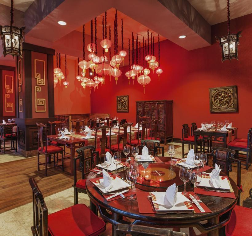 a dining room with red walls and tables and chandeliers at Spice Hotel & Spa - Ultra All Inclusive in Belek