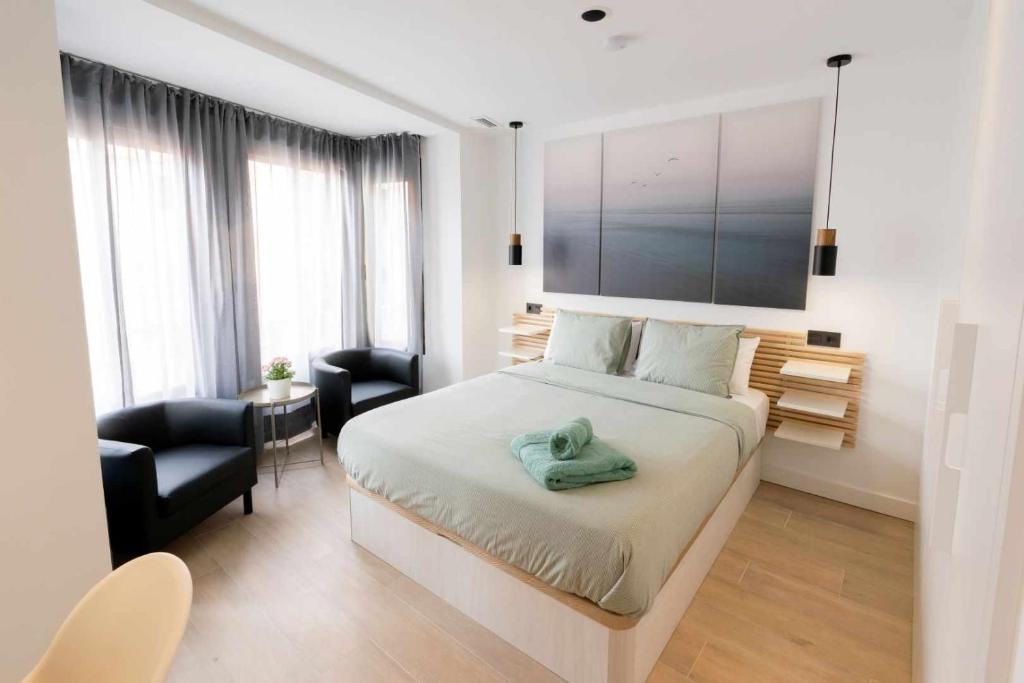 a bedroom with a bed and a desk and a chair at Apartamento Capri Living Suites en Castellon in Castellón de la Plana