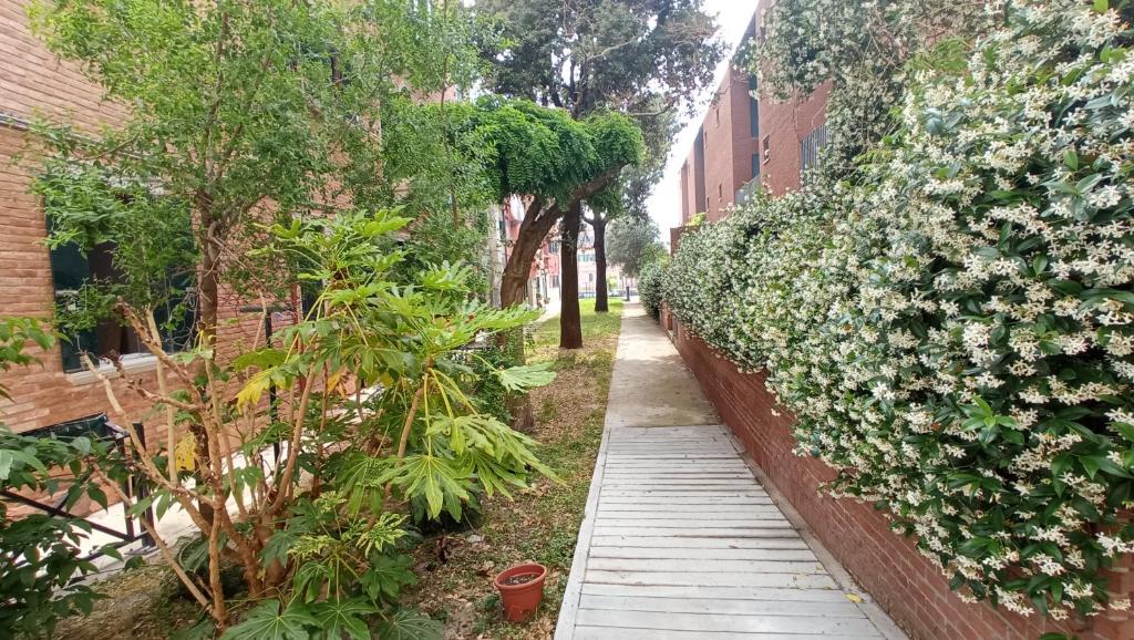 une passerelle dans un jardin à côté d'un bâtiment dans l'établissement Immersa nel verde, à Venise
