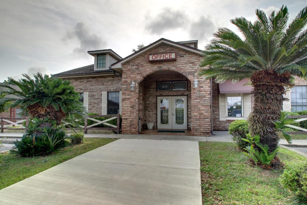 a house with a palm tree in front of it at HOTEL DEL SOL - Pensacola in Pensacola