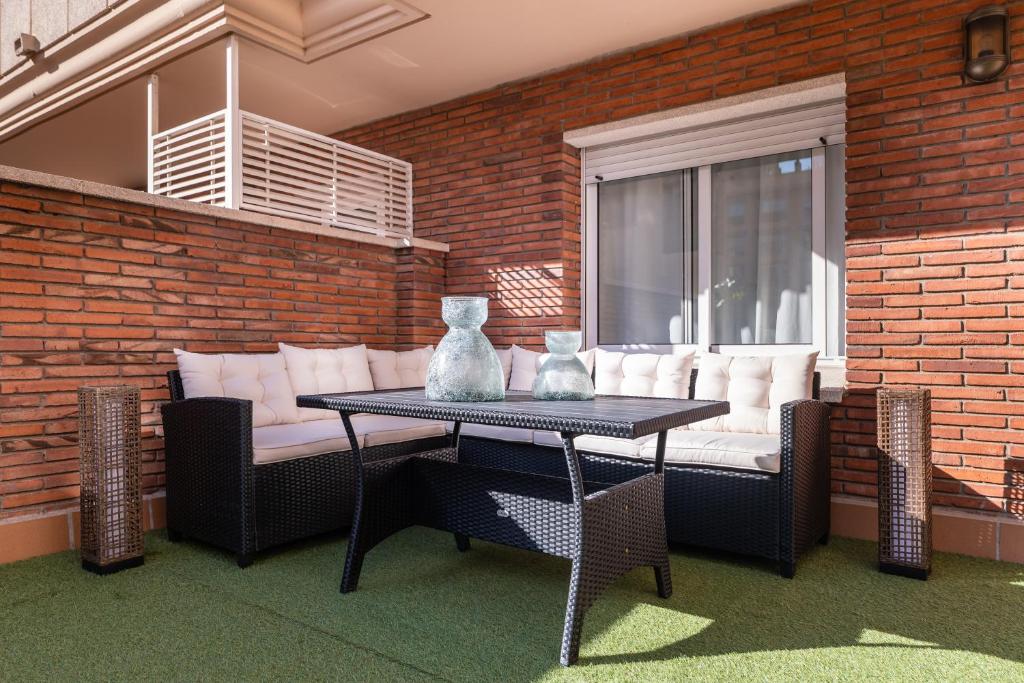 a table and chairs with vases on a patio at Aparthotel Napols - Abapart in Barcelona