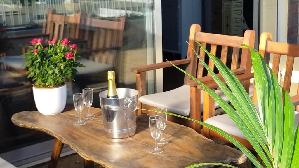 - une table en bois avec des verres à vin et une plante dans l'établissement Grand T2 Luxe Classé 4**** - Plein sud et très calme au Lavandou, au Lavandou