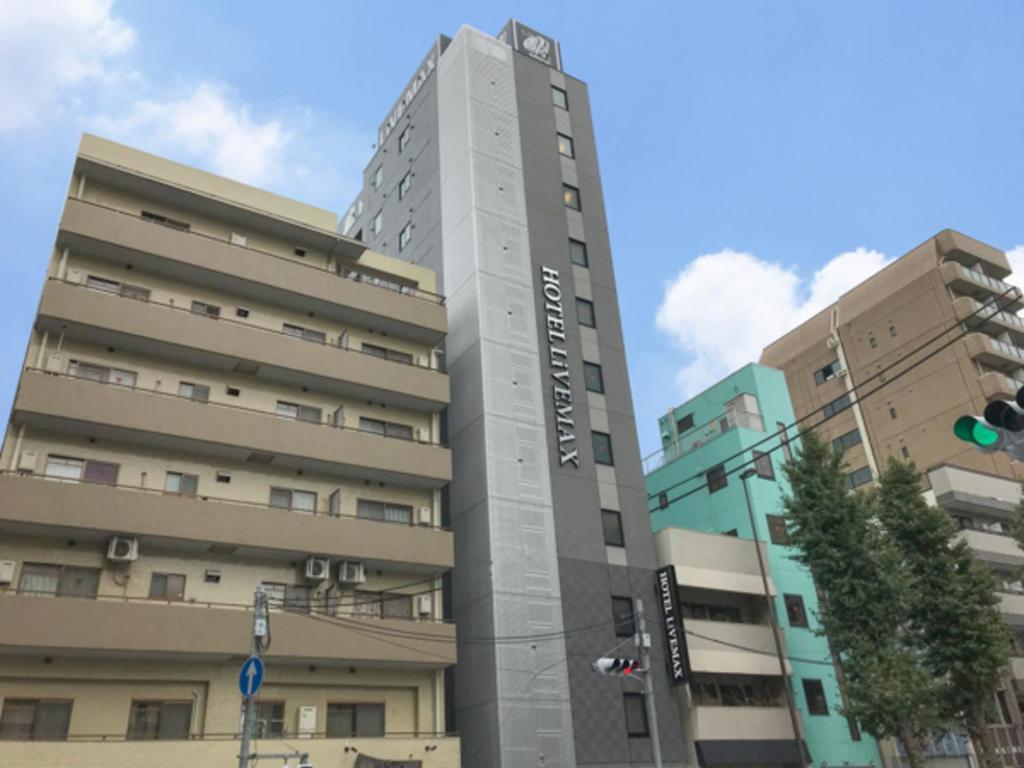 a tall building in front of two buildings at HOTEL LiVEMAX Asakusa-Ekimae in Tokyo