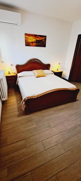 Bett in einem Schlafzimmer mit Holzboden in der Unterkunft Le Terrazze Studios 44G in Ferrara
