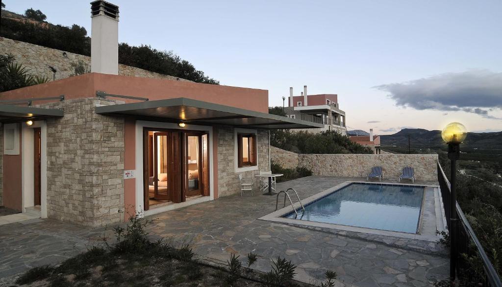 a house with a swimming pool next to a building at Karayiannis Villas in Nafplio