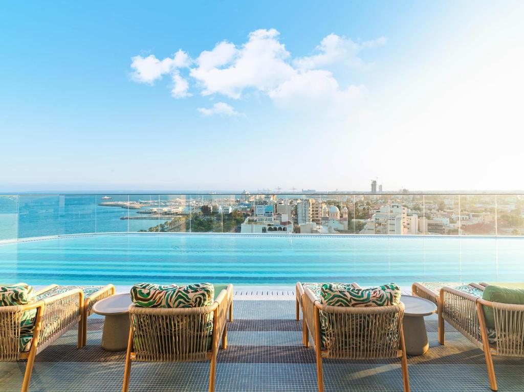 uma vista para a piscina a partir da varanda do hotel em NYX Hotel Limassol by Leonardo Hotels em Limassol