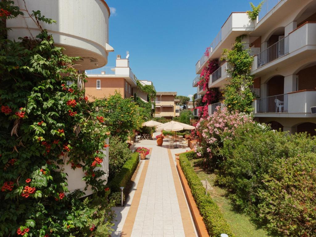 a walkway between two buildings with flowers and plants at I Cinque Pini in Follonica