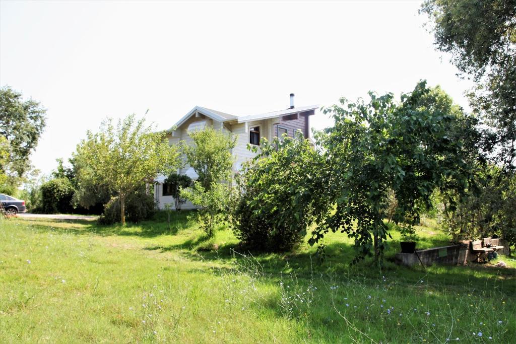 a white house with trees and a yard at WOODEN HOUSE in Preveza