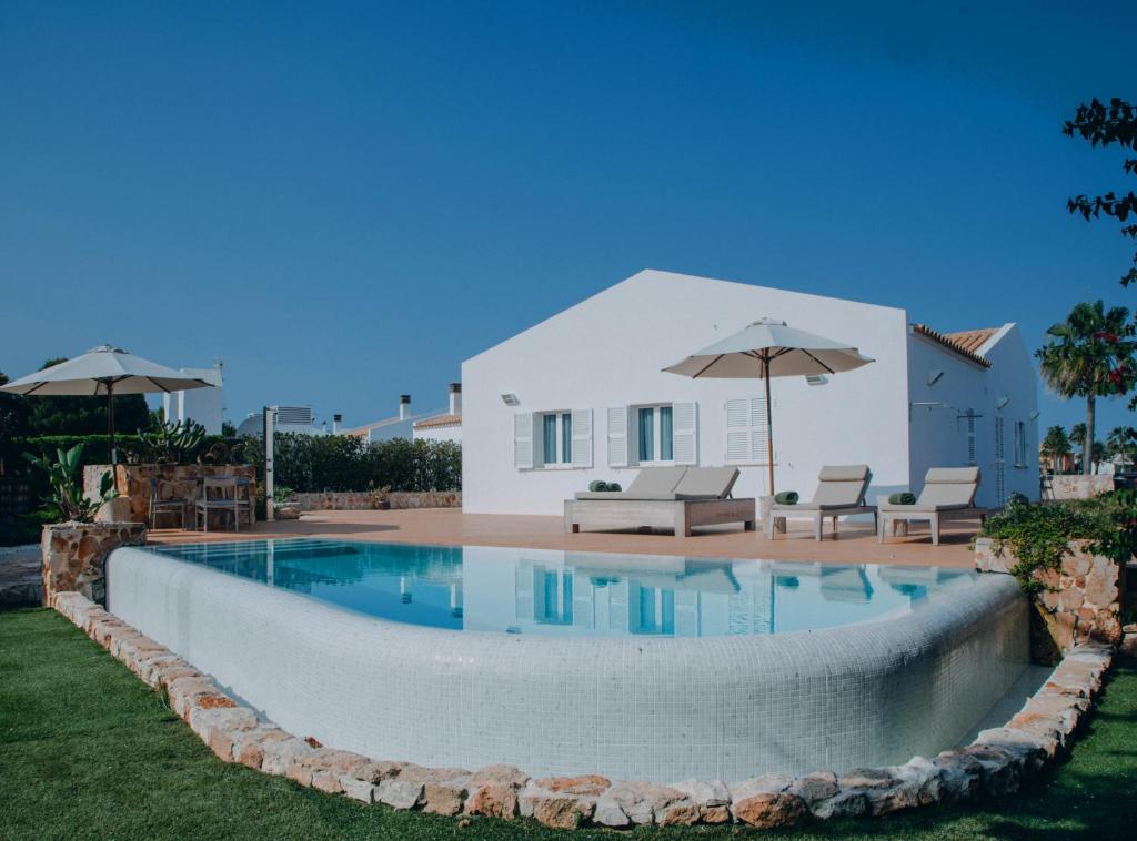 a swimming pool in the backyard of a villa at Lago Resort Menorca - Villas & Bungalows del Lago in Cala'n Bosch