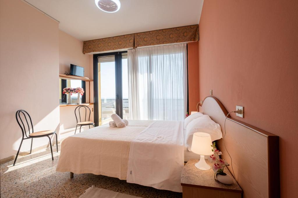 um quarto com uma cama e uma grande janela em Hotel Crown em Rimini
