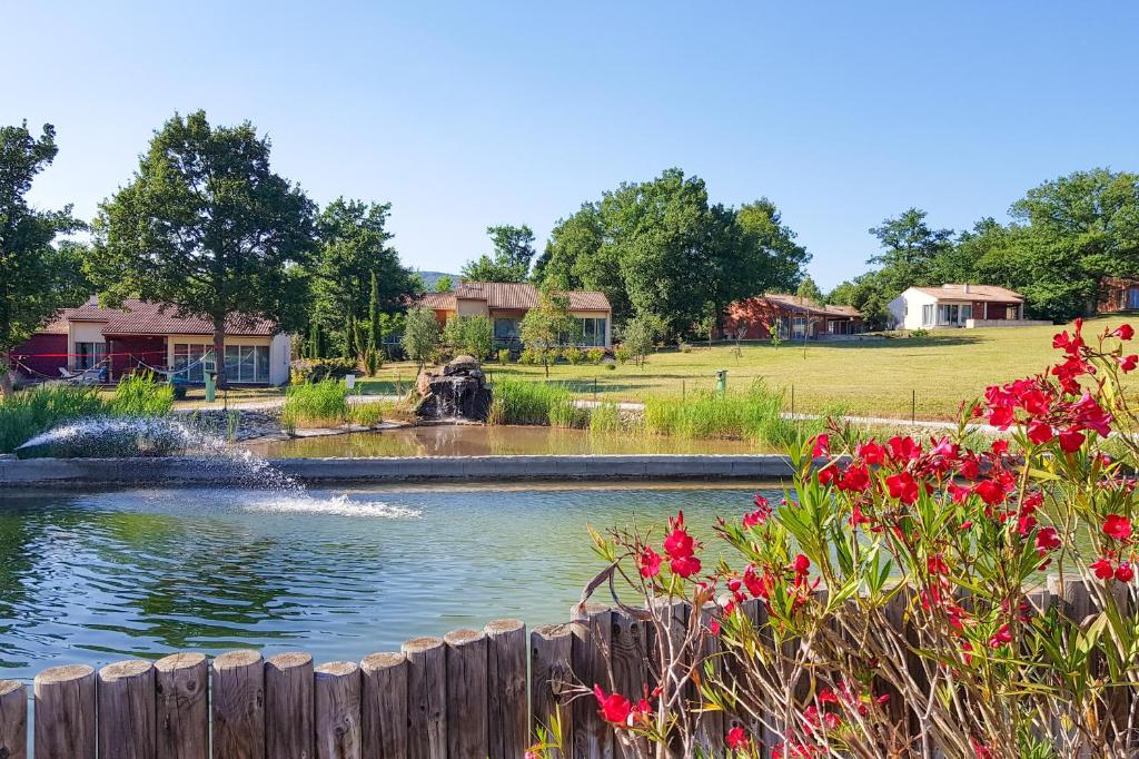 a fountain in a pond in a park with flowers at FranceComfort - L'Espinet in Quillan