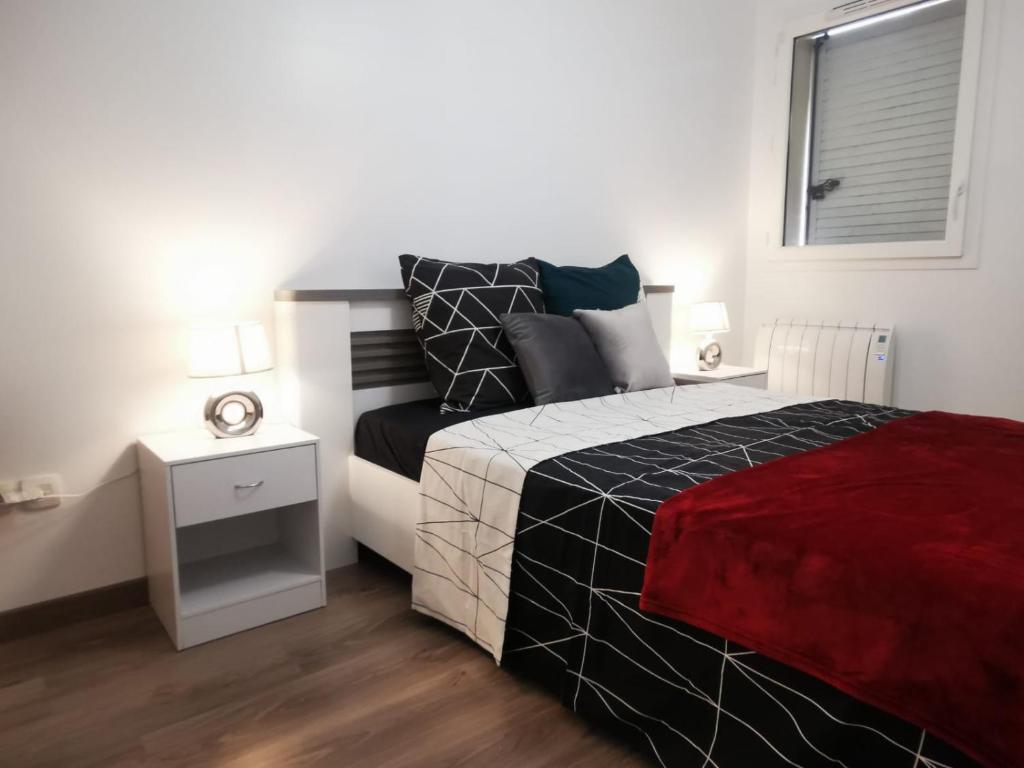 1 dormitorio con 1 cama con manta roja y ventana en Appartement Jelyad Mallard proche Disney, en Chanteloup-en-Brie