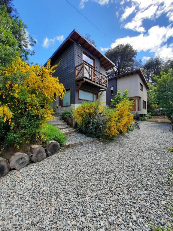 a house with a gravel driveway in front of it at Pacha Home By A.M.A in San Carlos de Bariloche