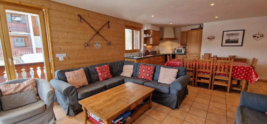 een woonkamer met banken en een tafel en een keuken bij Résid. Les Esserts A33 in Champoussin