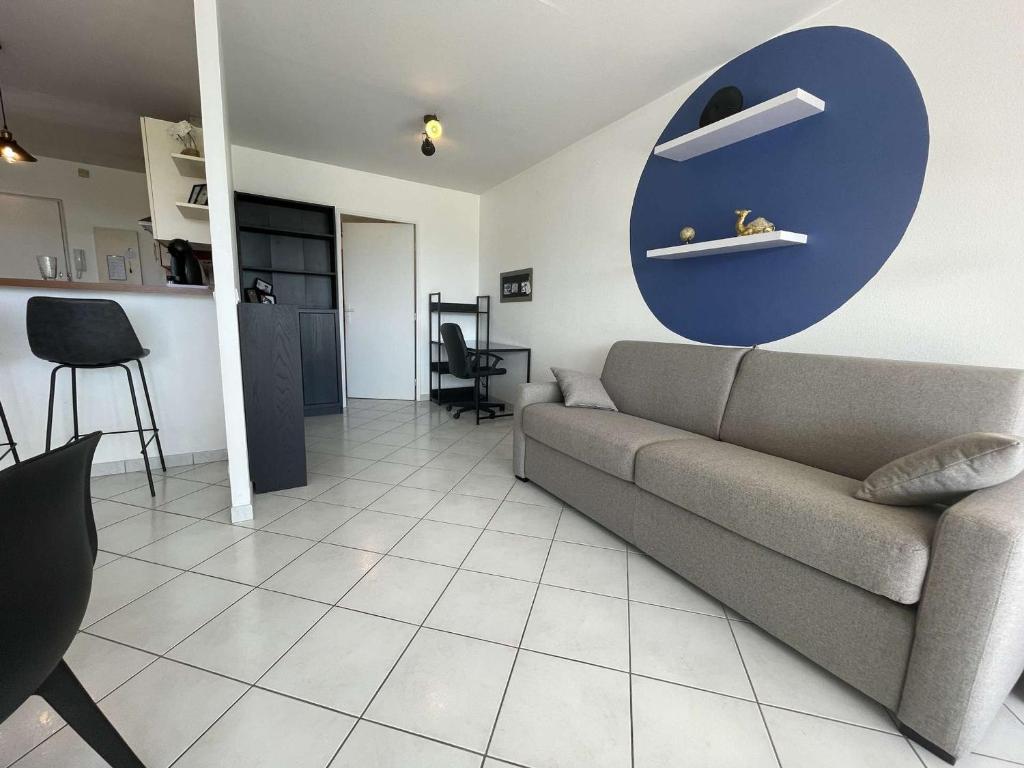 a living room with a couch and a blue circle on the wall at Appartement La Rochelle, 1 pièce, 2 personnes - FR-1-246-650 in La Rochelle