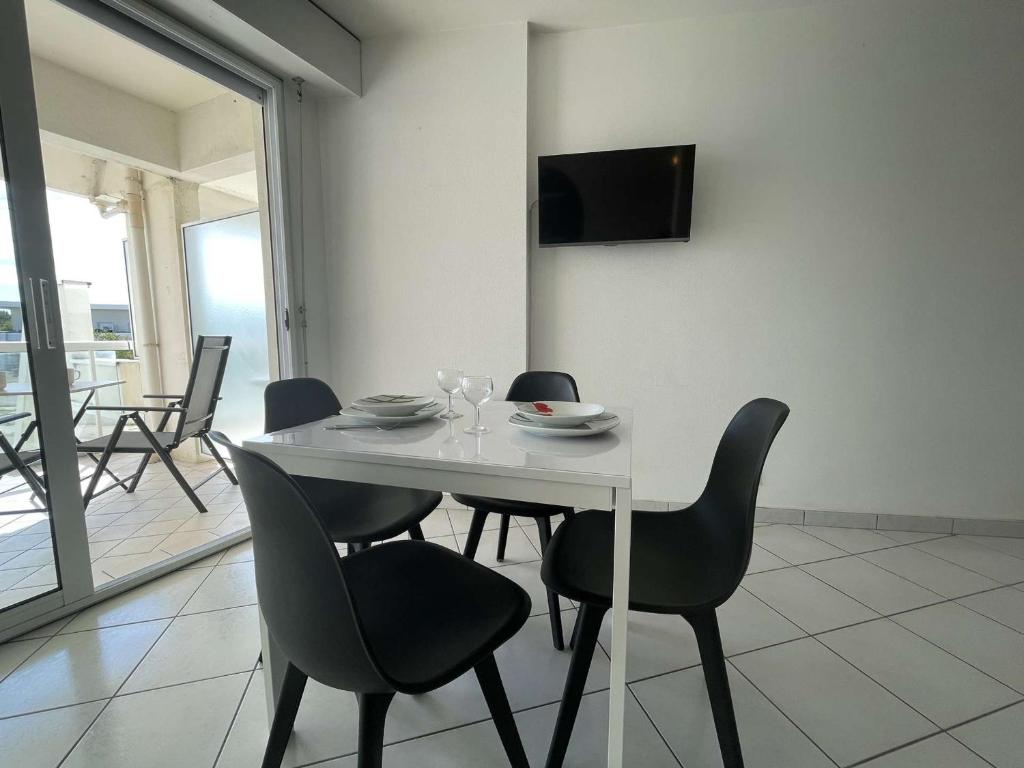 a dining room table with chairs and a television on a wall at Appartement La Rochelle, 1 pièce, 2 personnes - FR-1-246-650 in La Rochelle
