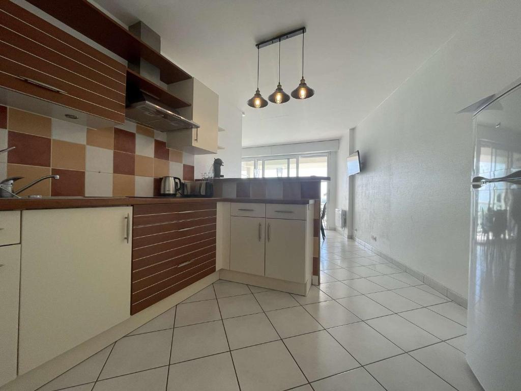 a kitchen with brown and white cabinets and a tile floor at Appartement La Rochelle, 1 pièce, 2 personnes - FR-1-246-650 in La Rochelle
